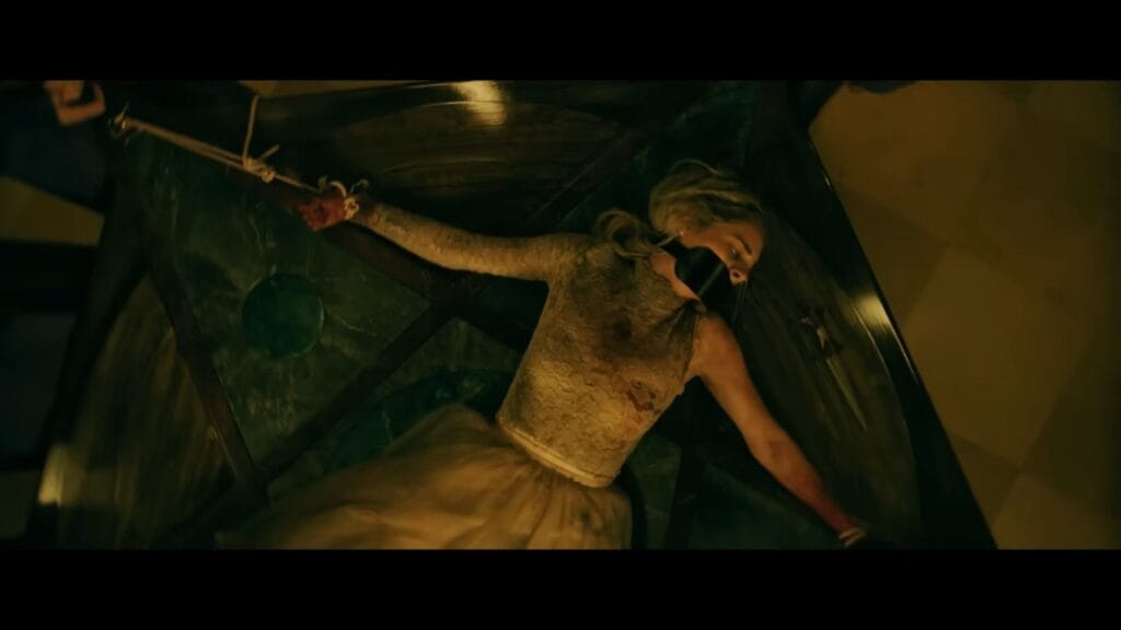 Grace (Samara Weaving) is bound to a large table with a gag in her mouth, a high-stakes moment from the horror sequel Ready or Not 2: Here I Come.