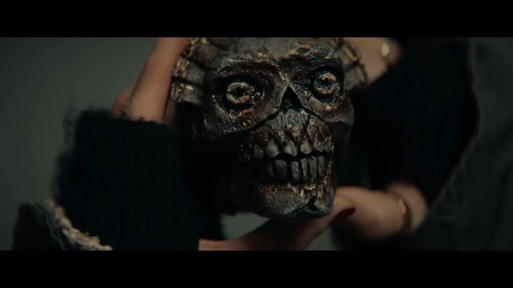 A detailed close-up of the cursed ancient skull whistle held by trembling hands, the central mystery of the 2026 horror movie Whistle.