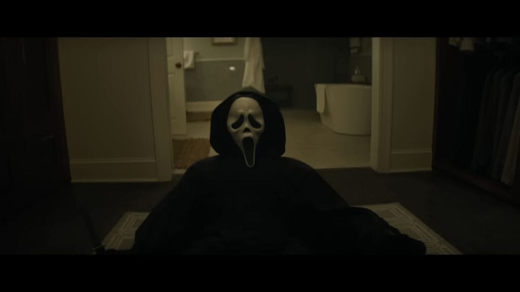 Ghostface sits on the floor in front of a modern bathroom, a chilling confrontation scene from the Scream 7 ending explained.