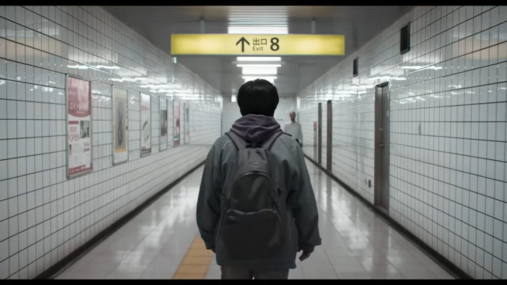A protagonist with a backpack walks down an empty, sterile white-tiled subway corridor toward a glowing yellow sign reading Exit 8 in a scene from the liminal space psychological thriller.