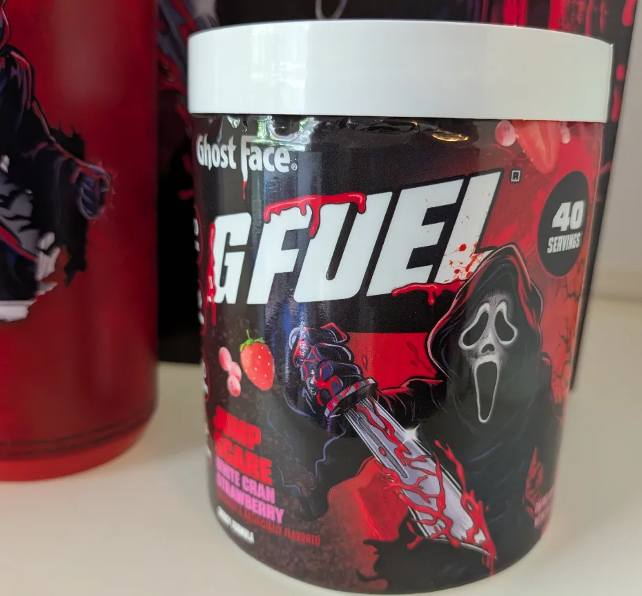 A close-up of the G Fuel Ghost Face Jump Scare energy formula tub in White Cran Strawberry flavor, featuring the classic slasher villain.