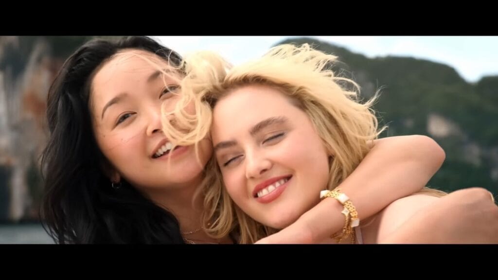 Lana Condor as Max hugging Kathryn Newton as Sara tightly while both smile happily outdoors in a scene from The Devil's Mouth.