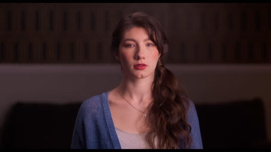 Gea Rose Henry as Velvet staring directly into the camera during a documentary interview sequence in Velvicide.