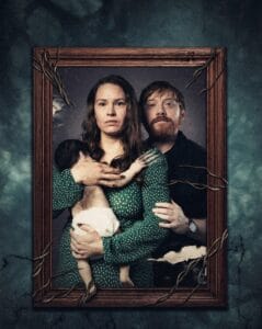 Official movie poster for Nightborn featuring a family portrait in a wooden frame entwined with thorny roots, showing a mother holding a hairy infant beside her husband.