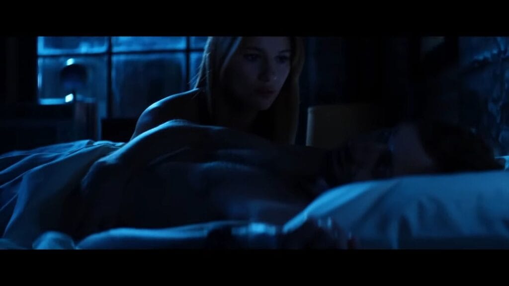 Companion android Sara leaning over David lying in bed under blue dim lighting in Soulm8te.