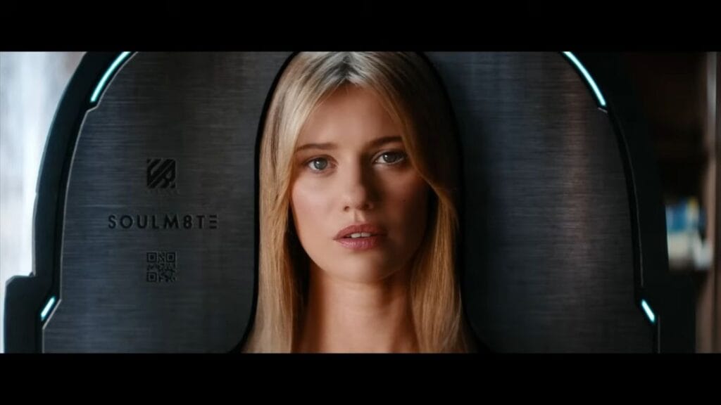 Lily Sullivan as the companion android Sara framed inside a sleek metallic charging pod display in Soulm8te.