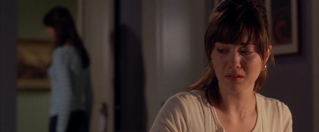 A close-up of Wendy looking devastated with teary eyes inside a house in Final Destination 3.