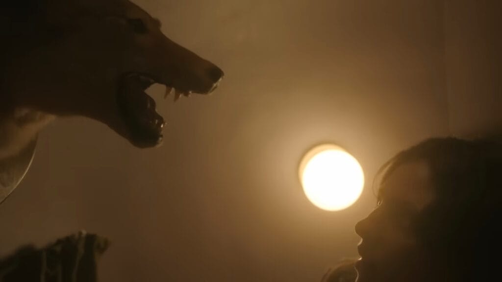A woman staring in terror at a mounted snarling taxidermy coyote head on the wall in Hellcat.