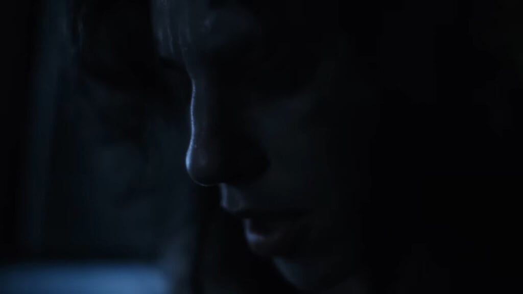 A close-up side profile of Lena's face lit in cold blue shadows inside a dark vehicle in Hellcat.