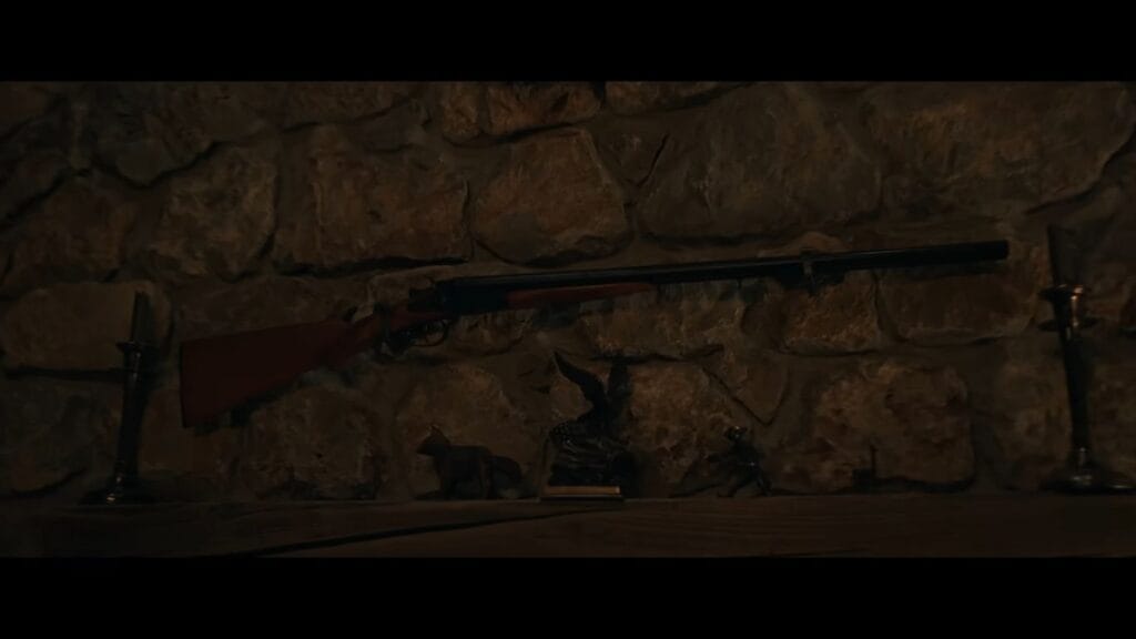 A double-barreled shotgun mounted on a rustic stone fireplace mantle above animal figurines in a scene from Resident Evil.