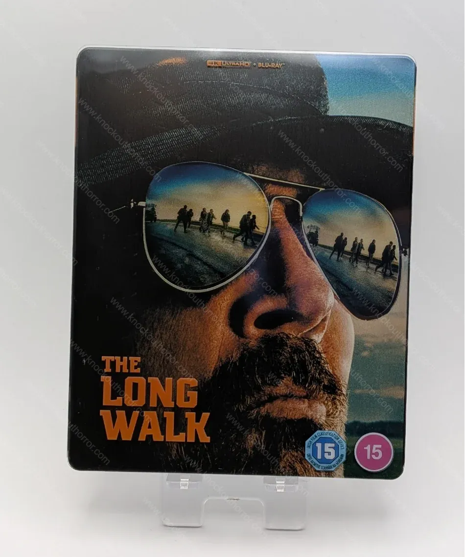 Front cover of The Long Walk 4K Blu-ray steelbook featuring The Major in sunglasses with clear slipcover overlay showing walkers reflected in the lenses.