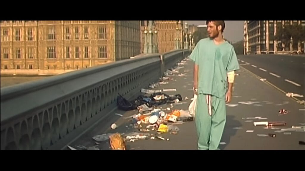 Cillian Murphy as Jim wearing hospital scrubs and walking down an empty, litter-strewn Westminster Bridge in 28 Days Later.