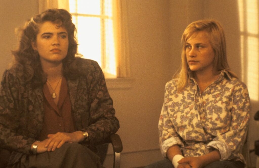 Heather Langenkamp as Nancy Thompson and Patricia Arquette as Kristen Parker seated beside each other during group therapy in A Nightmare on Elm Street 3: Dream Warriors.