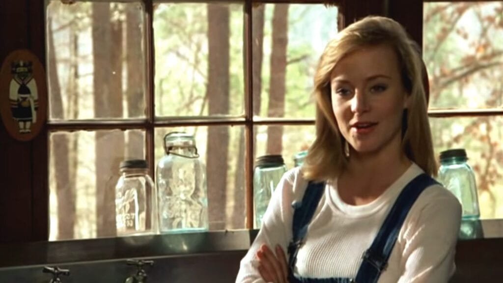 Jennifer Cooke as Megan smiling confidently with arms crossed by a window in Friday the 13th Part VI: Jason Lives.