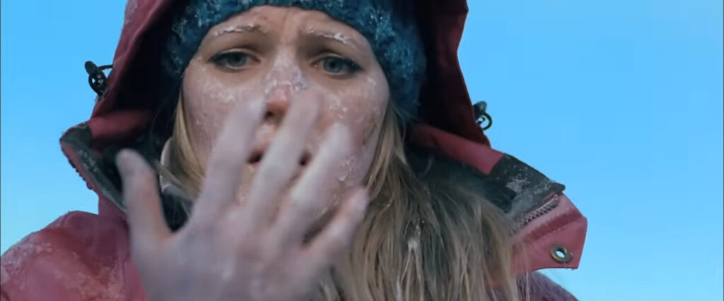 Emma Bell as Parker staring in horror at her severely frostbitten hand and icy face in Frozen.