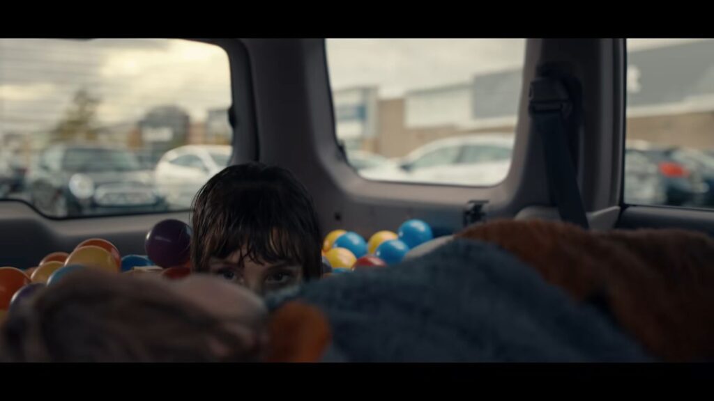Jessica Chastain's character peering out from a ball pit in the back of a vehicle in Other Mommy.