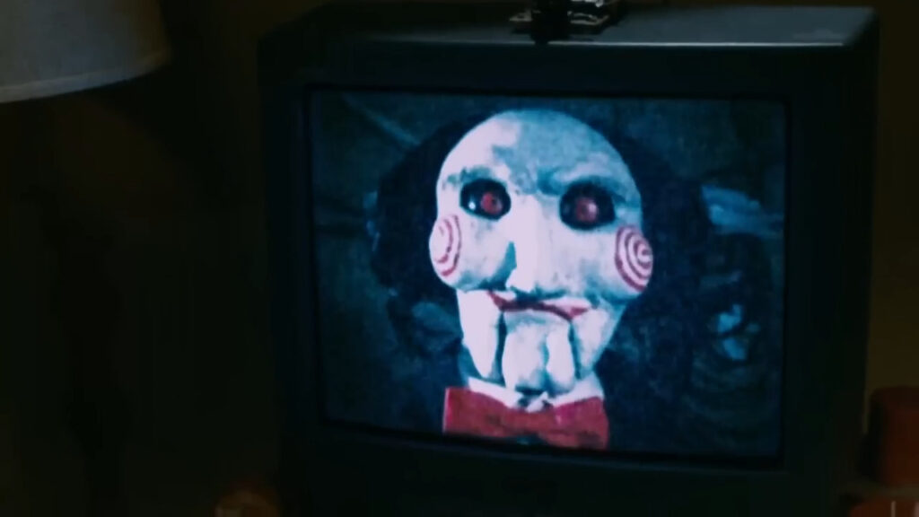 Billy the Puppet's face displayed on an old television screen in Saw IV.