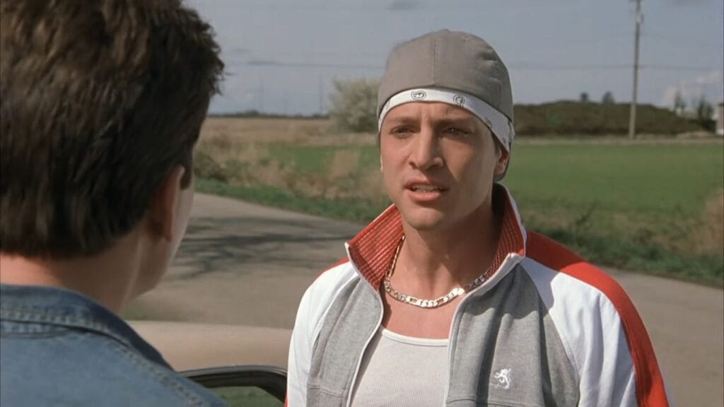 Simon Rex wearing a do-rag and tracksuit talking seriously next to an open field in Scary Movie 3.