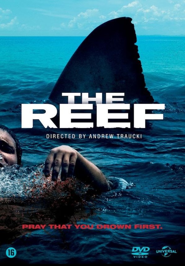 Official movie cover for The Reef featuring a swimmer struggling in deep water with a massive Great White shark dorsal fin rising behind them.