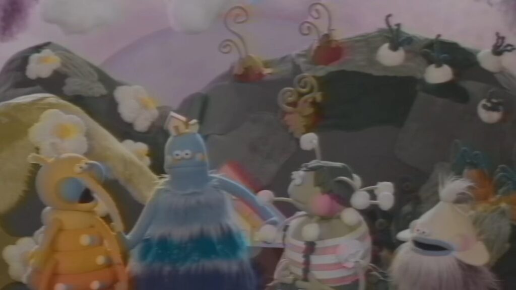 Claymation figures standing in front of a colorful, textured backdrop in V/H/S/Mixtape.