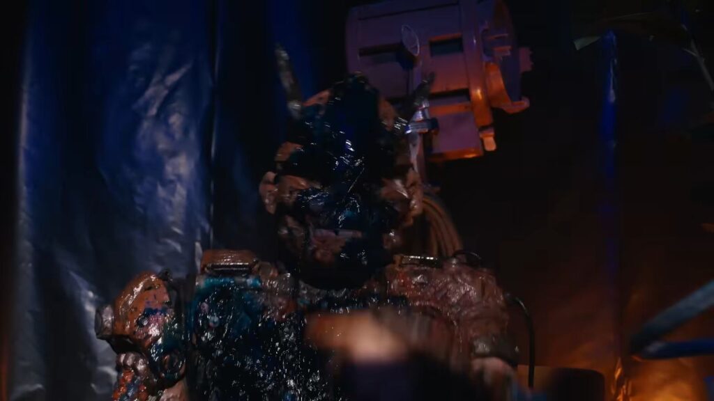 A heavily mutated figure covered in dark goo and muck in V/H/S/Mixtape.
